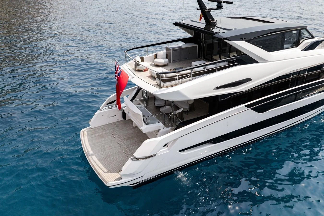 The sleek yacht showcases a luxurious aft deck with ample seating and a swim platform, perfect for relaxation and water activities. aboard 82 OCEAN ENCLOSED Yacht for Sale