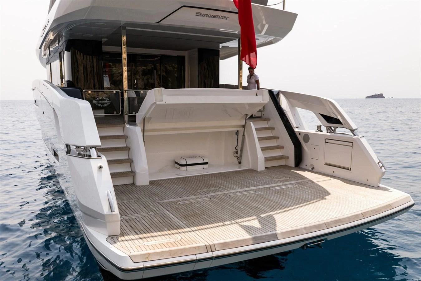 The yacht's aft deck features a spacious swim platform and steps leading to the main deck, perfect for enjoying the water. aboard 82 OCEAN ENCLOSED Yacht for Sale