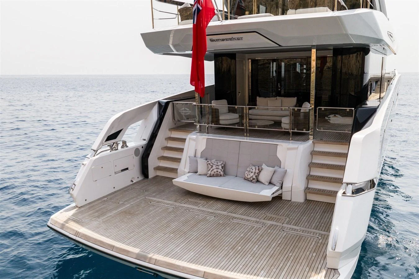 The yacht's aft deck features a spacious lounging area with comfortable seating and easy access to the water. aboard 82 OCEAN ENCLOSED Yacht for Sale