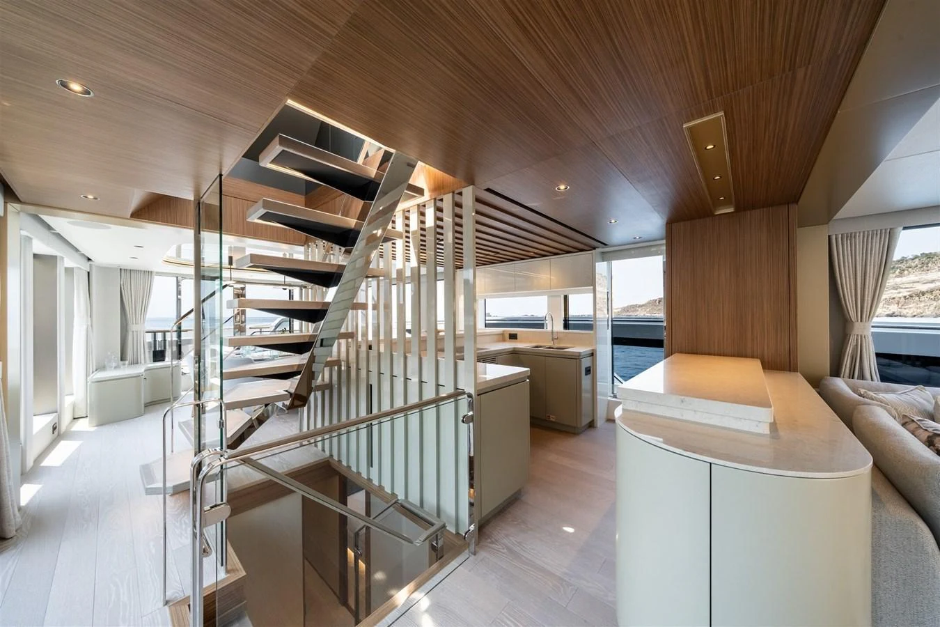 The main salon features a modern design with ample natural light and a stylish staircase. aboard 82 OCEAN ENCLOSED Yacht for Sale