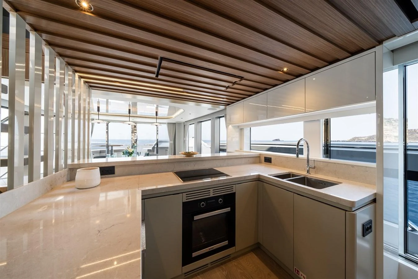 The modern galley features sleek cabinetry, ample counter space, and large windows offering stunning sea views. aboard 82 OCEAN ENCLOSED Yacht for Sale