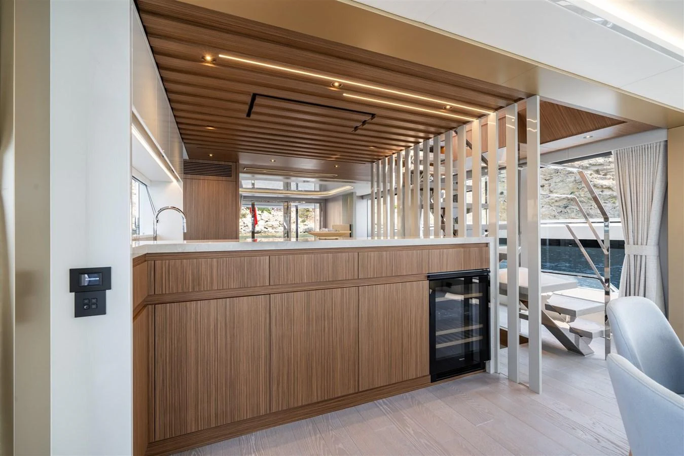 The yacht's galley features modern wood finishes and ample natural light. aboard 82 OCEAN ENCLOSED Yacht for Sale