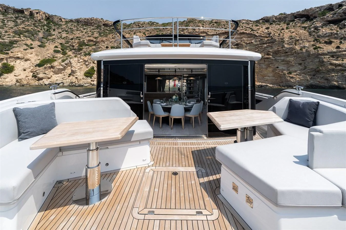The aft deck features luxurious seating and dining areas with a stunning view of the surrounding landscape. aboard 82 OCEAN ENCLOSED Yacht for Sale