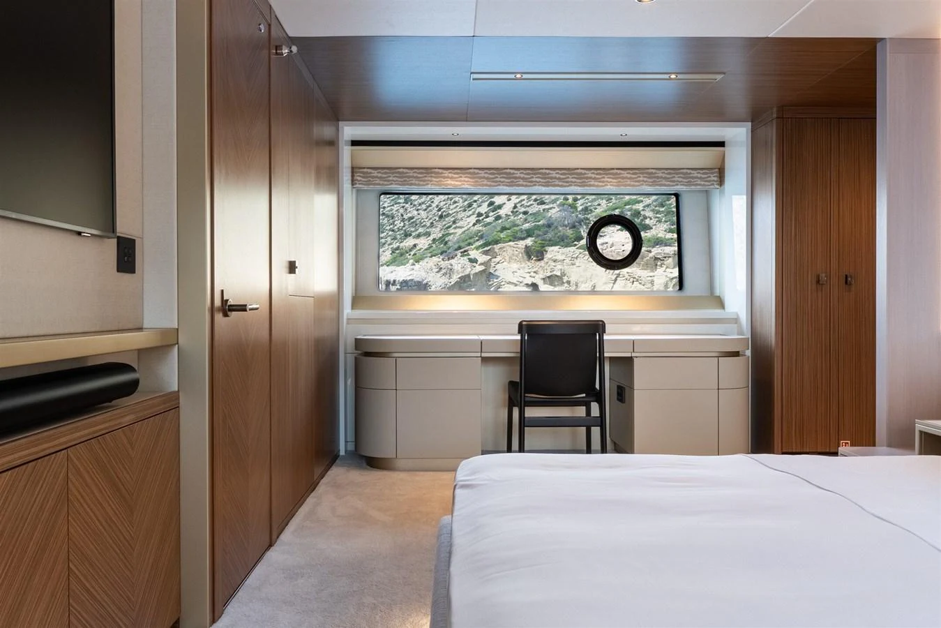 The stateroom features a large window with a scenic view, a desk, and a comfortable bed. aboard 82 OCEAN ENCLOSED Yacht for Sale