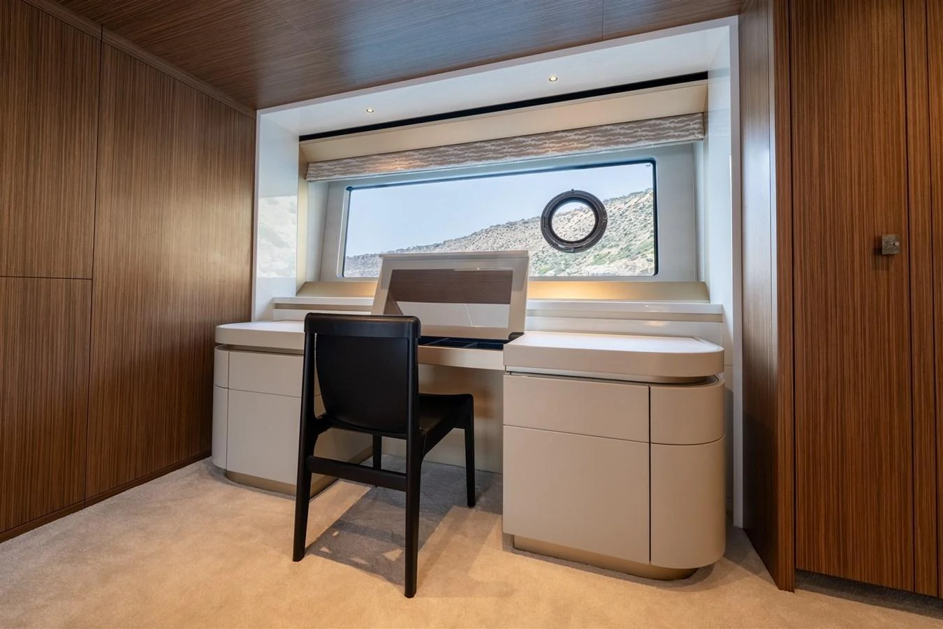 A sophisticated yacht office with a sleek desk and a view of the sea through a large window. aboard 82 OCEAN ENCLOSED Yacht for Sale
