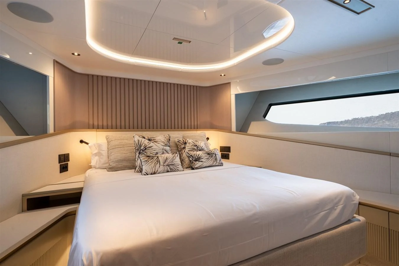 The stateroom features a luxurious bed with elegant lighting and modern decor. aboard 82 OCEAN ENCLOSED Yacht for Sale