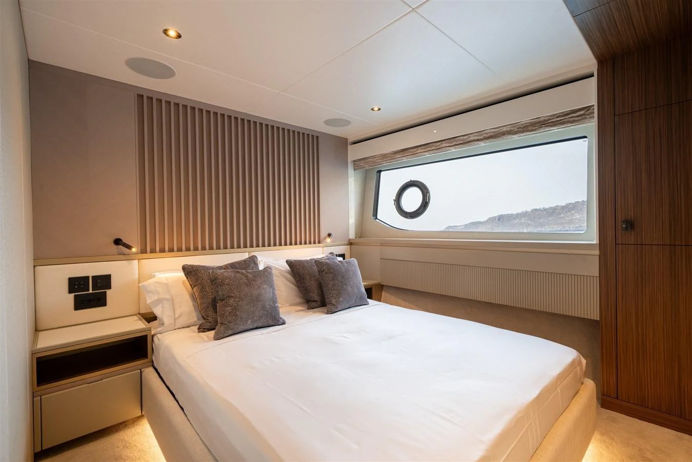 A luxurious stateroom featuring a large bed, modern decor, and a scenic window view. aboard 82 OCEAN ENCLOSED Yacht for Sale