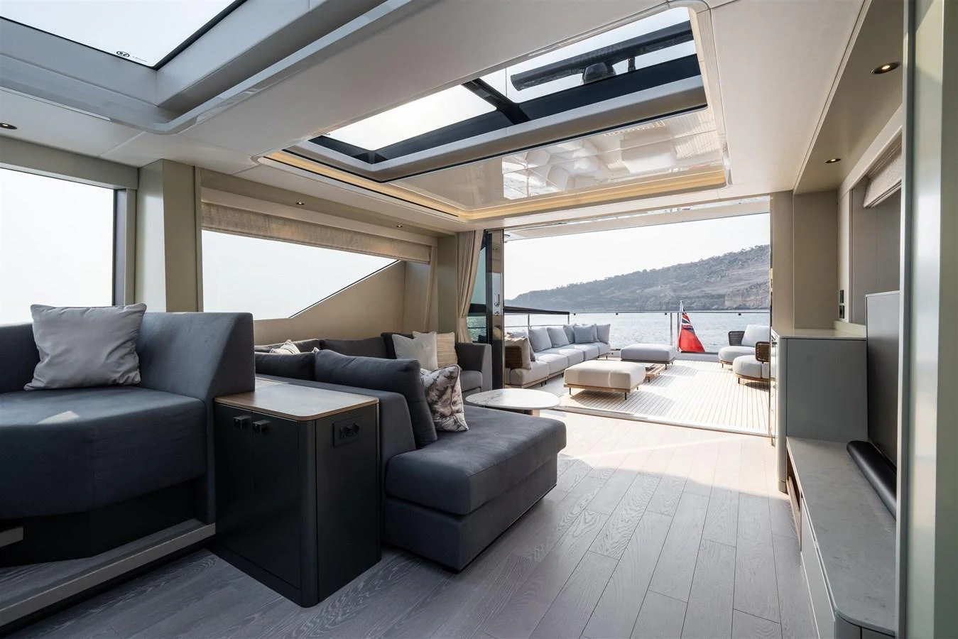 The salon offers a spacious and luxurious seating area with large windows and a view of the aft deck. aboard 82 OCEAN ENCLOSED Yacht for Sale