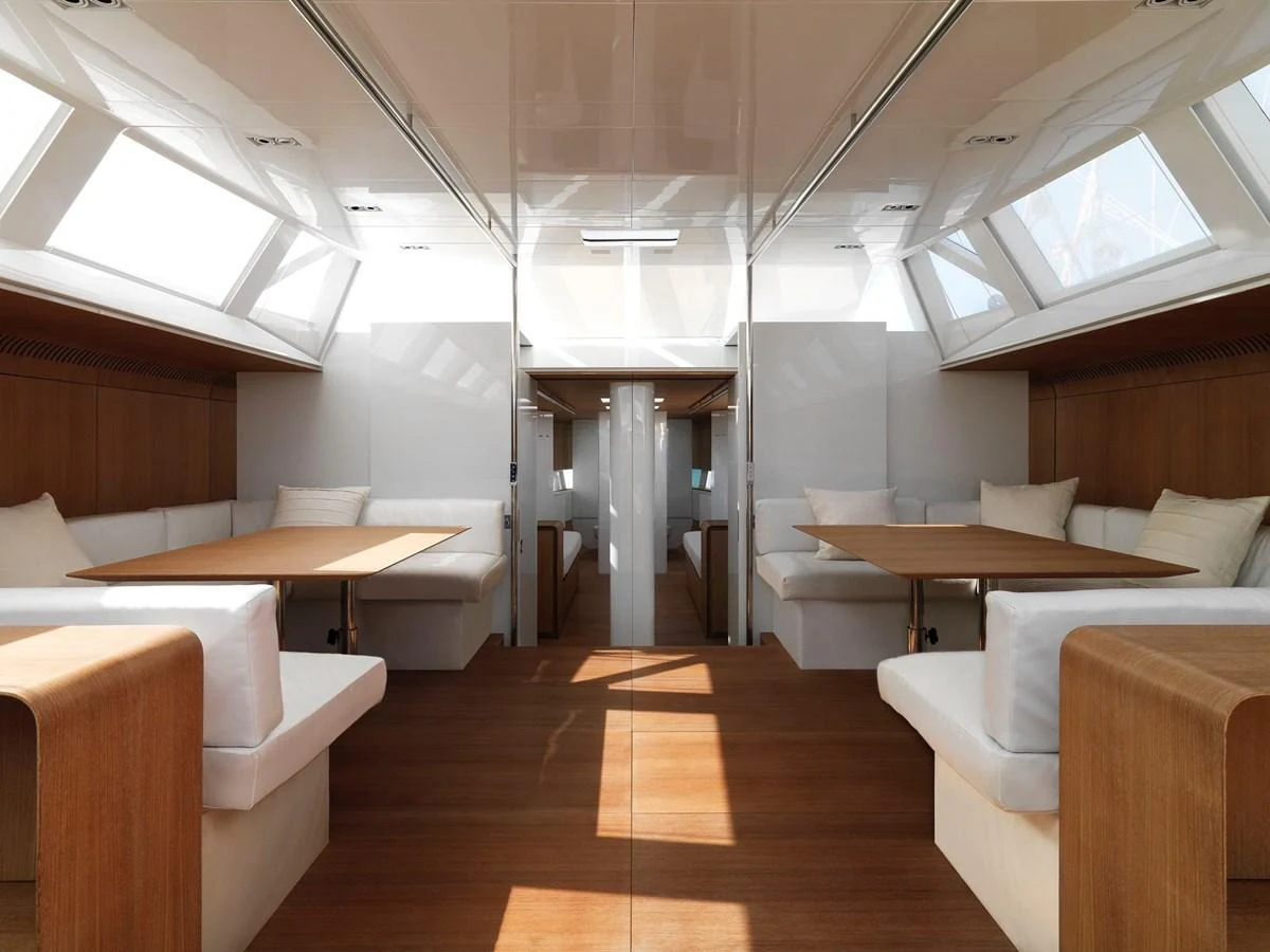 The yacht's interior features a spacious and well-lit dining area with elegant wooden furnishings and ample seating. aboard POLYTROPON II Yacht for Sale