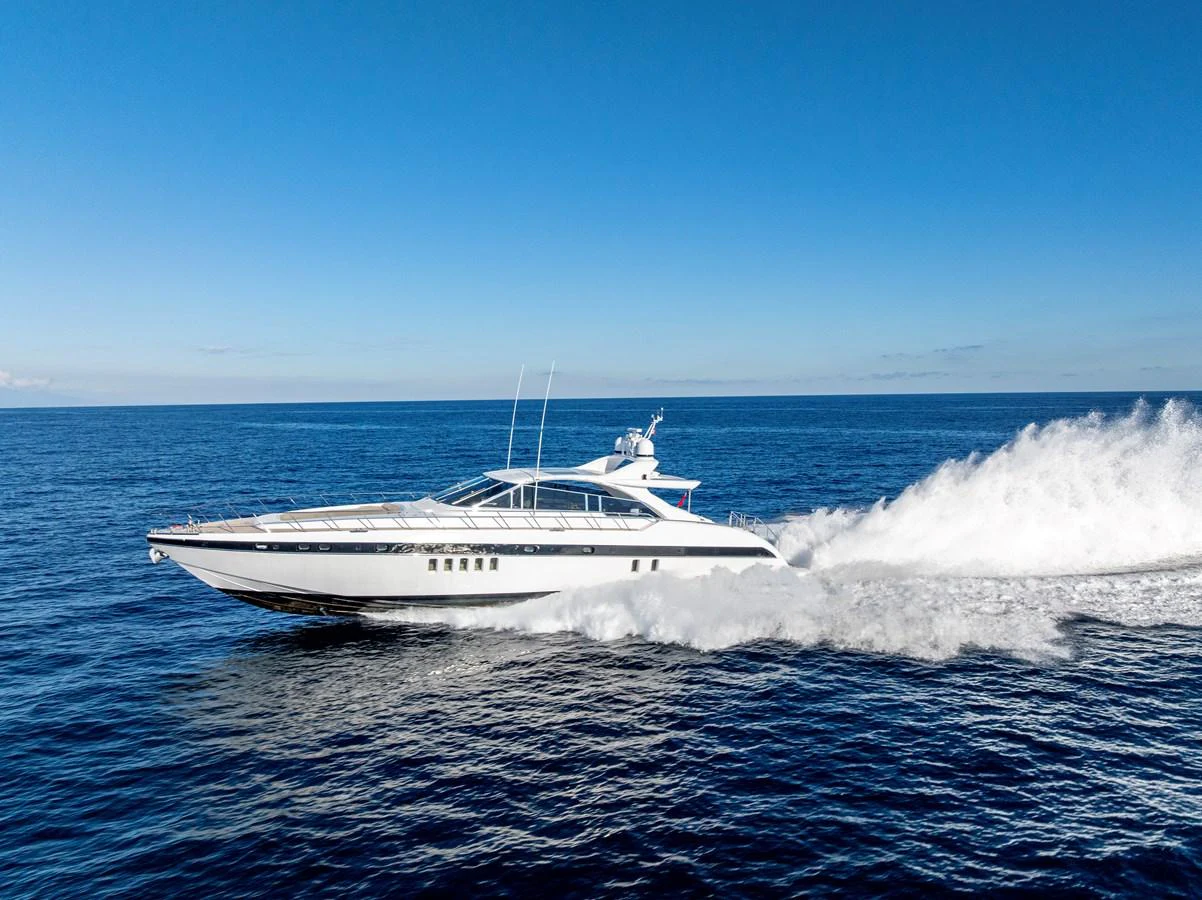A sleek yacht cruises swiftly across the open sea under a clear blue sky. aboard K GRACE Yacht for Sale