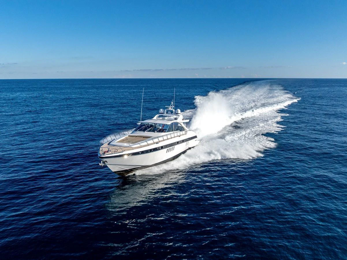 A sleek yacht cruises swiftly across the open sea under a clear blue sky. aboard K GRACE Yacht for Sale