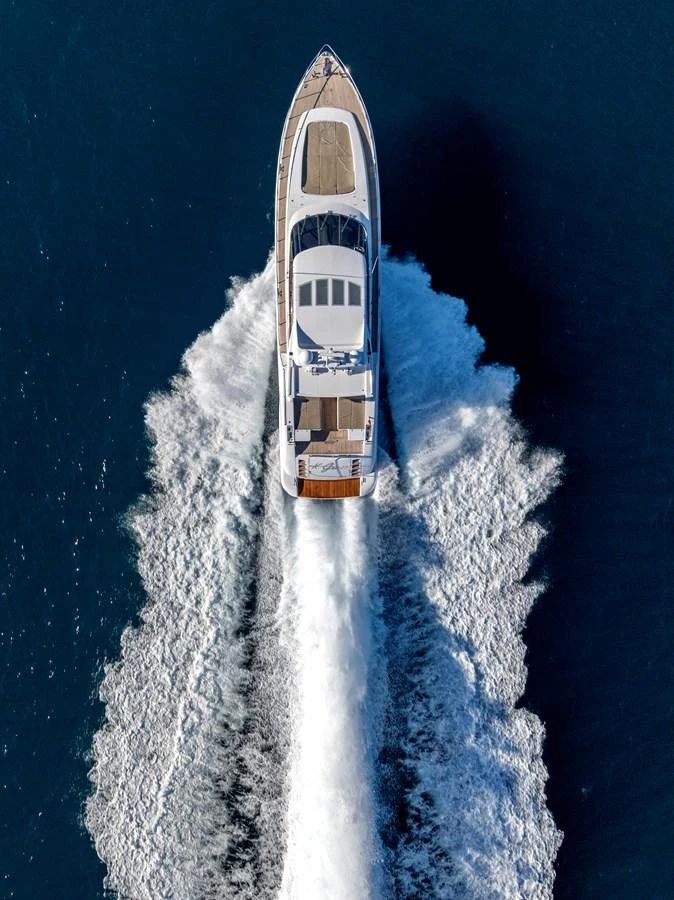 A stunning aerial view of a yacht cruising through the deep blue waters, leaving a trail of white wake behind. aboard K GRACE Yacht for Sale