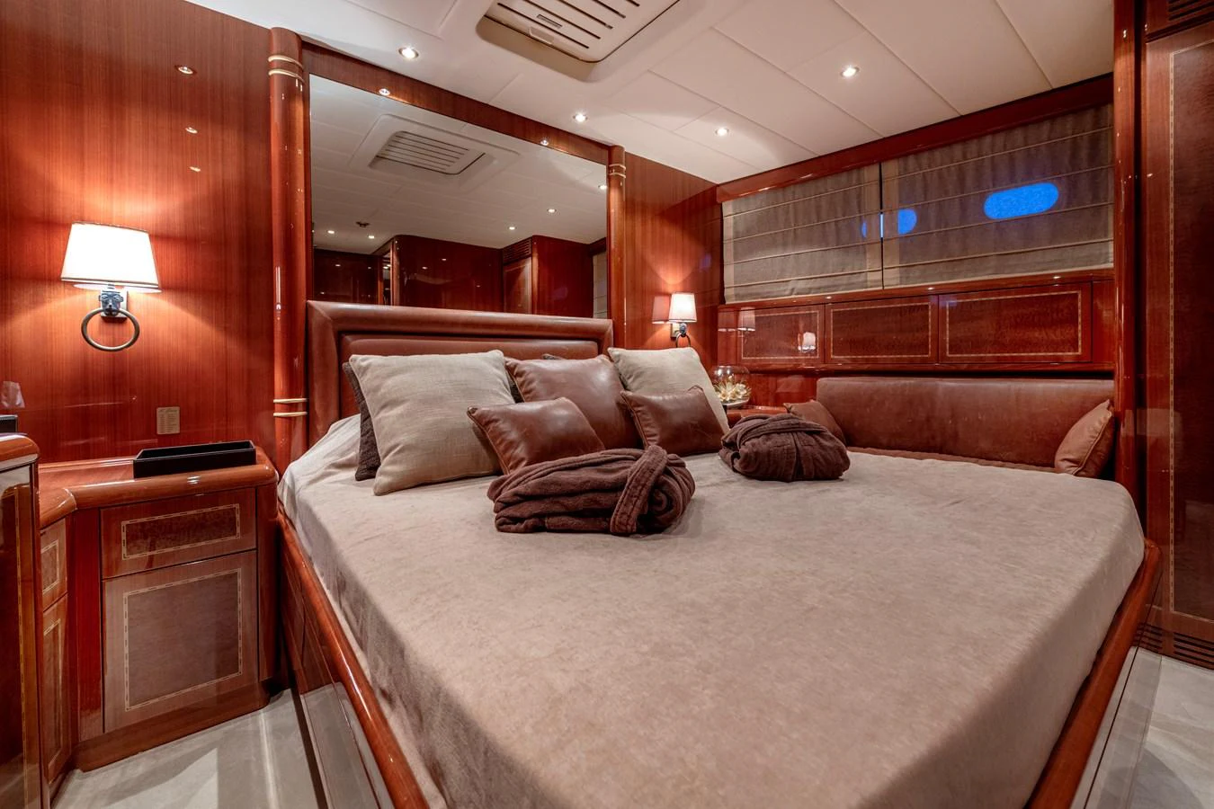 The master stateroom features a luxurious bed with elegant wood paneling and ambient lighting. aboard K GRACE Yacht for Sale