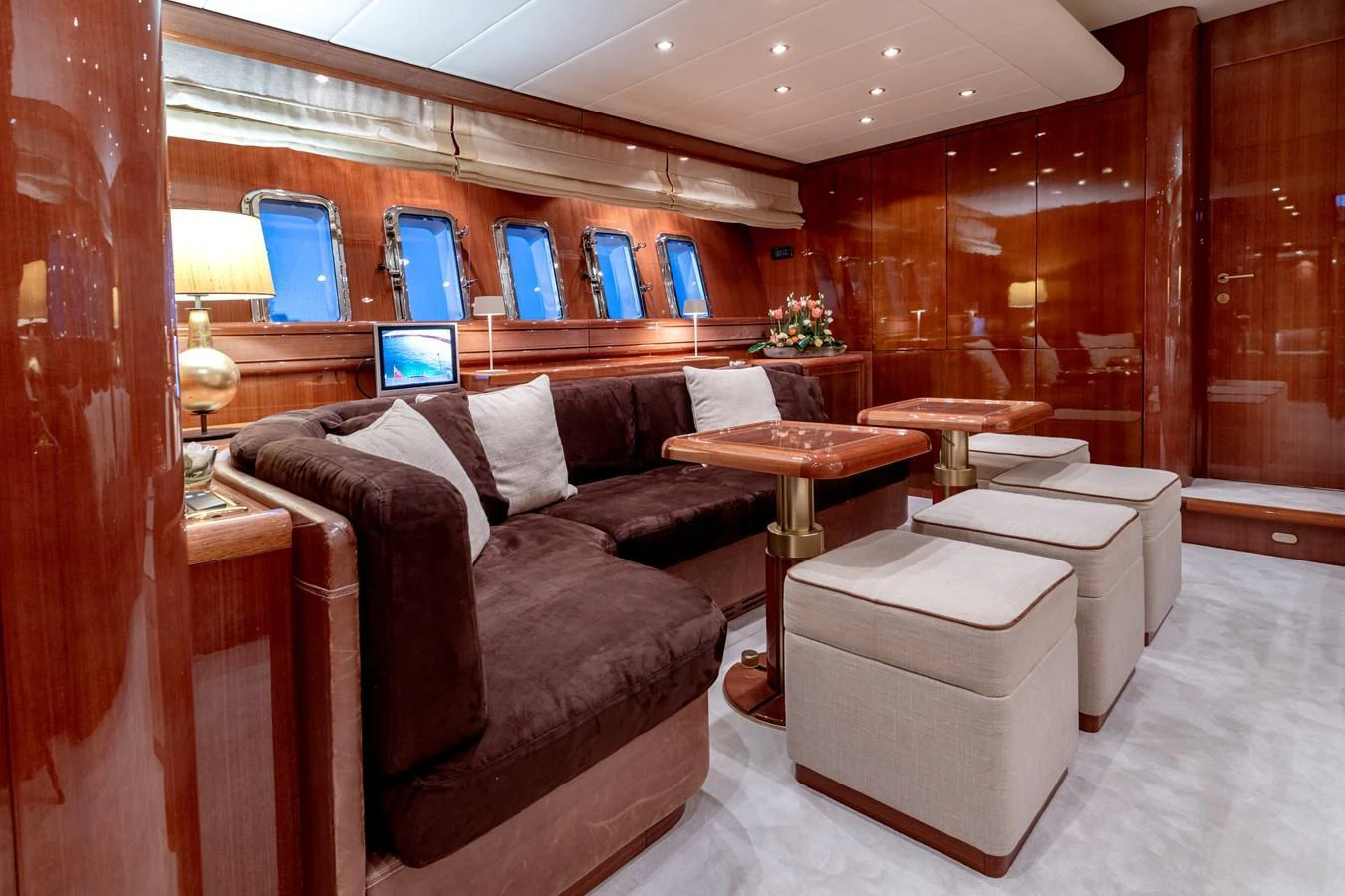 The yacht's salon features plush seating, warm wood finishes, and ample natural light from the windows. aboard K GRACE Yacht for Sale