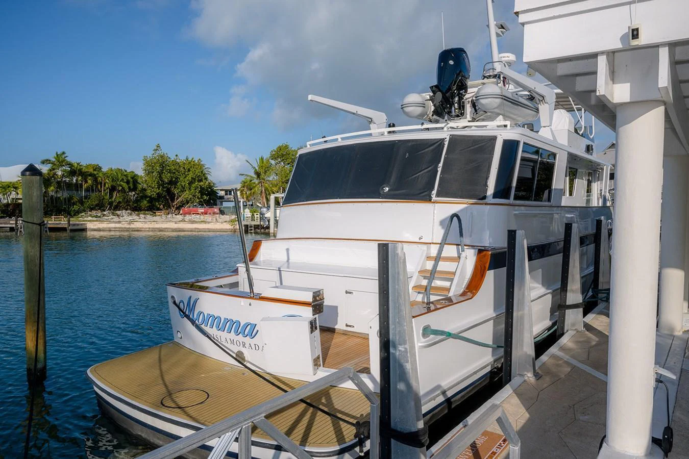 The yacht is docked at a marina, showcasing its sleek exterior and inviting deck area. aboard MAMA BEAR Yacht for Sale