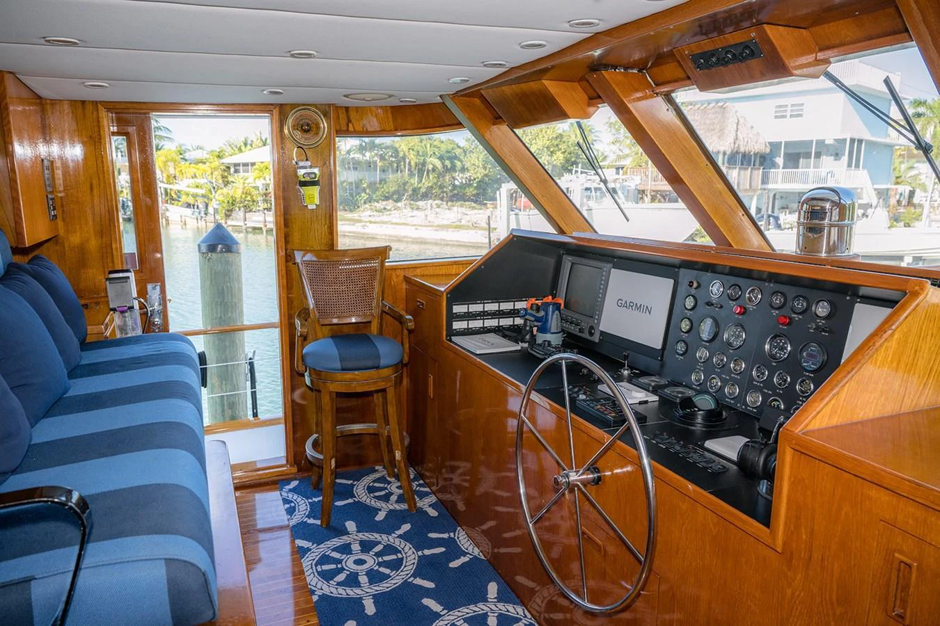 The helm area features a well-equipped control station with a comfortable seating arrangement and large windows for excellent visibility. aboard MAMA BEAR Yacht for Sale