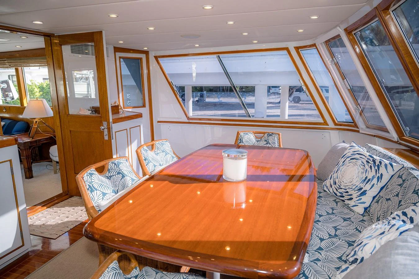 The yacht's dining area features a polished wooden table surrounded by comfortable, patterned chairs and large windows offering ample natural light. aboard MAMA BEAR Yacht for Sale