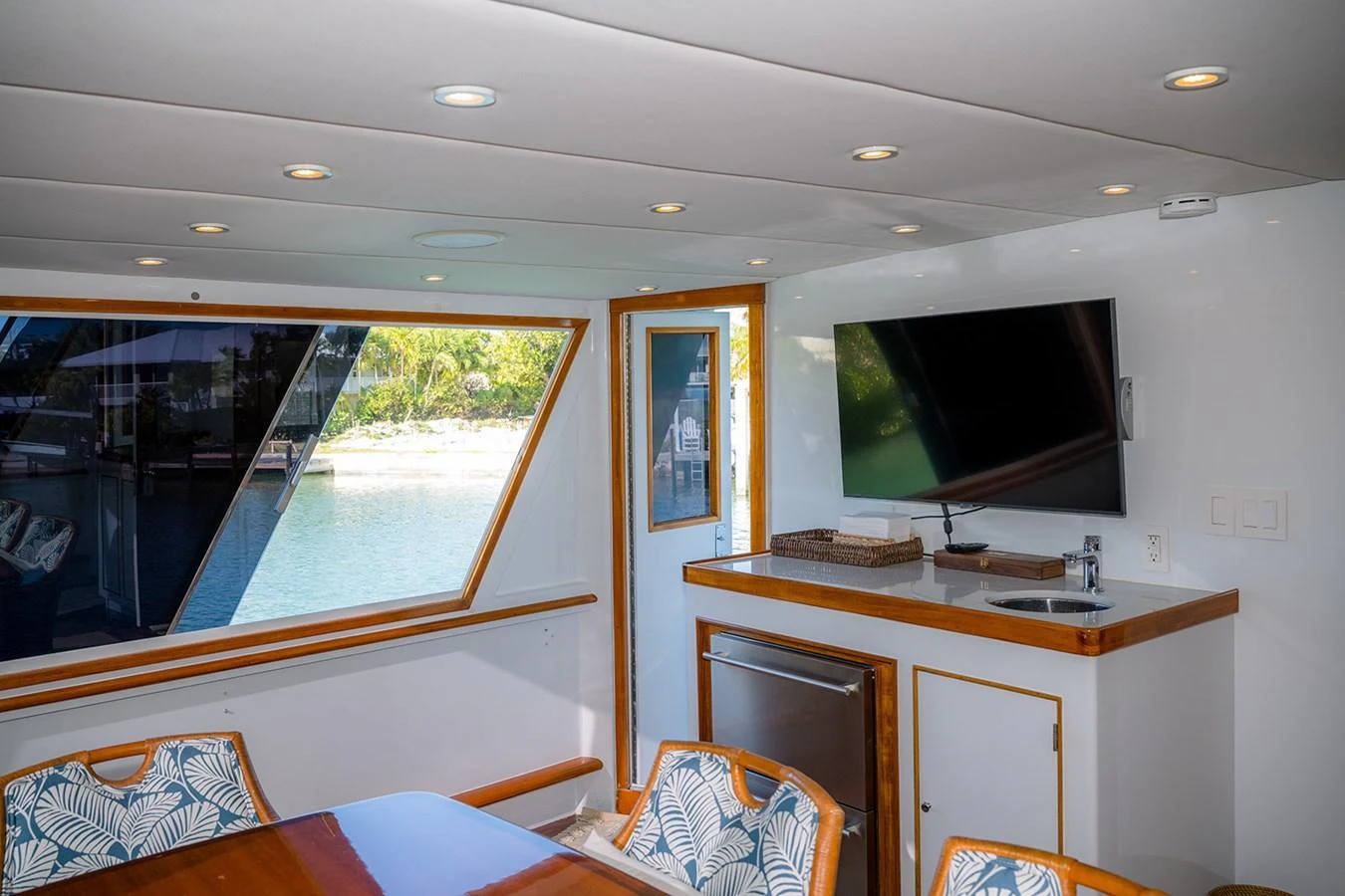 The salon features a comfortable dining area with large windows offering scenic views. aboard MAMA BEAR Yacht for Sale