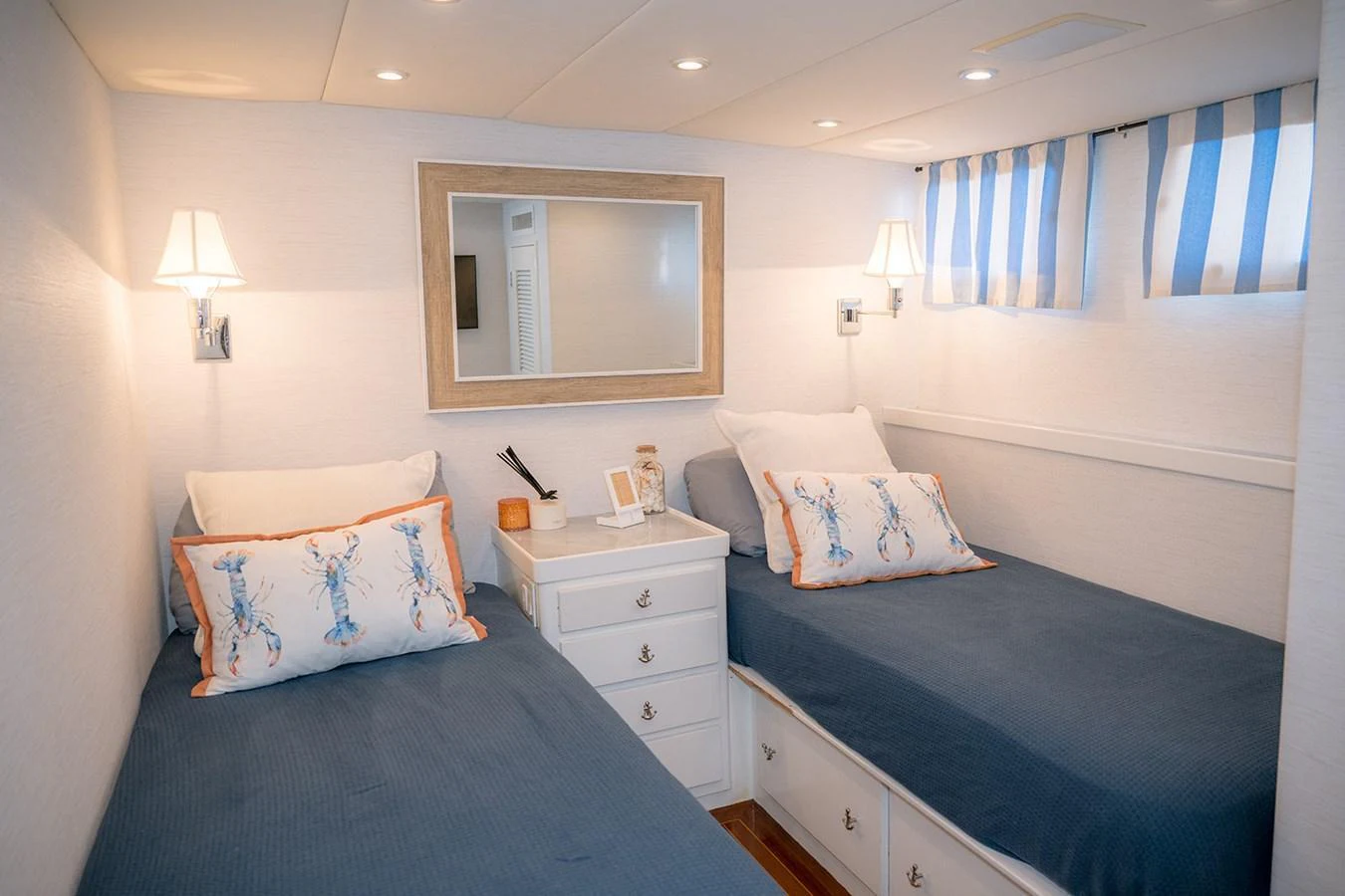 A cozy twin stateroom with elegant bedding and soft lighting. aboard MAMA BEAR Yacht for Sale