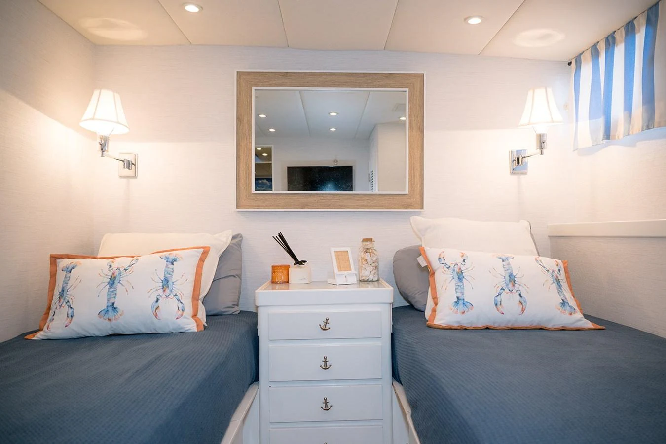 The guest stateroom features twin beds with nautical-themed decor and soft lighting. aboard MAMA BEAR Yacht for Sale