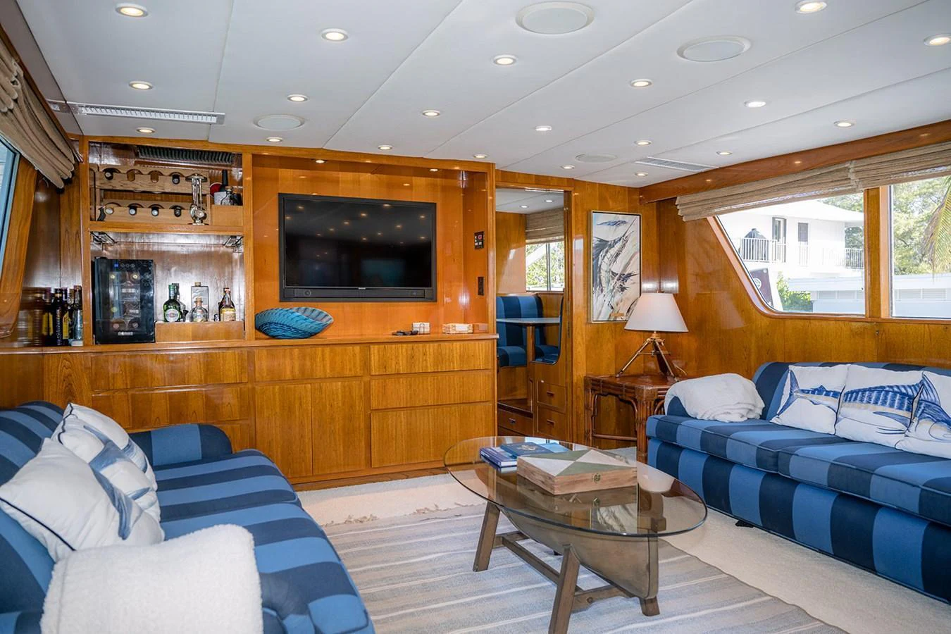 The yacht's salon features plush seating, a large flat-screen TV, and elegant wooden cabinetry. aboard MAMA BEAR Yacht for Sale