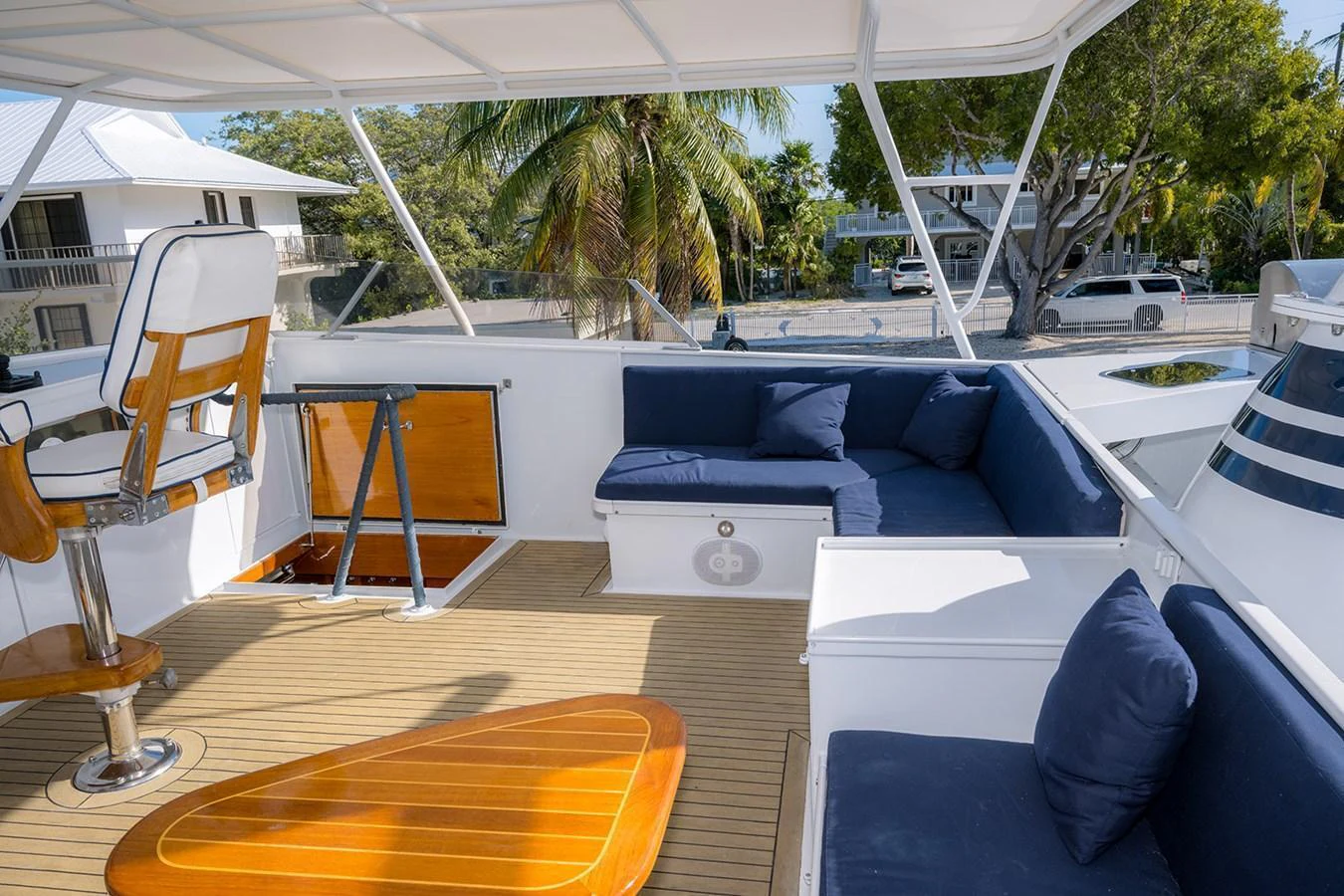 The flybridge offers a comfortable seating area with plush cushions and a helm station, perfect for enjoying the view. aboard MAMA BEAR Yacht for Sale