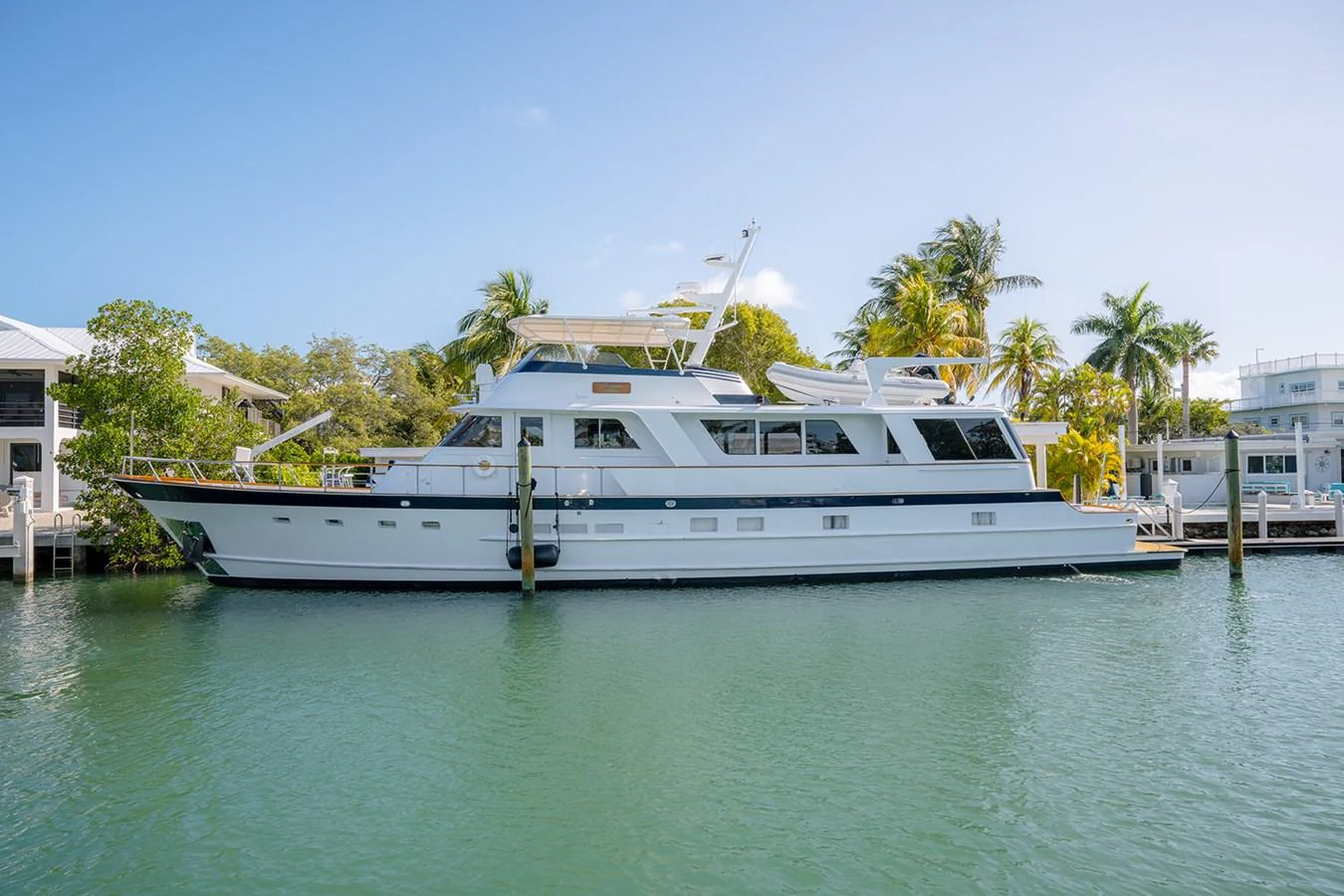 A classic motor yacht is docked in a serene marina, showcasing its elegant lines and spacious decks. aboard MAMA BEAR Yacht for Sale