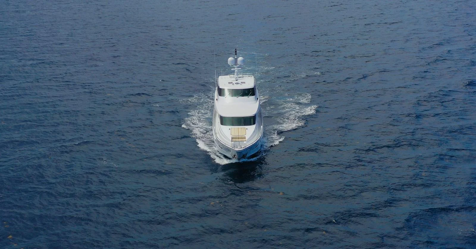 A sleek yacht cruises forward on open water, showcasing its elegant design. aboard PRIME TIME Yacht for Sale