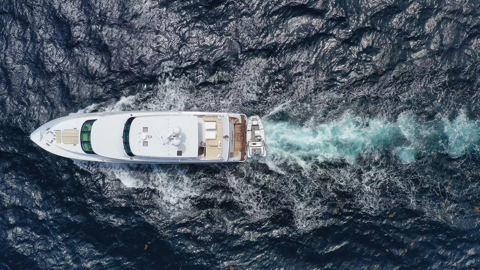 A stunning aerial view of a yacht cruising through the water, leaving a beautiful wake behind. aboard PRIME TIME Yacht for Sale