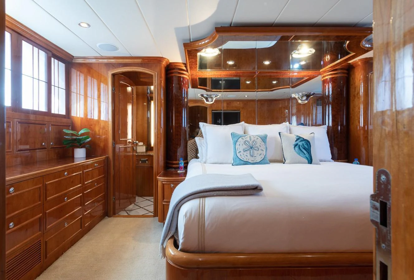 The master stateroom features luxurious wood paneling and elegant decor, creating a warm and inviting atmosphere. aboard PRIME TIME Yacht for Sale