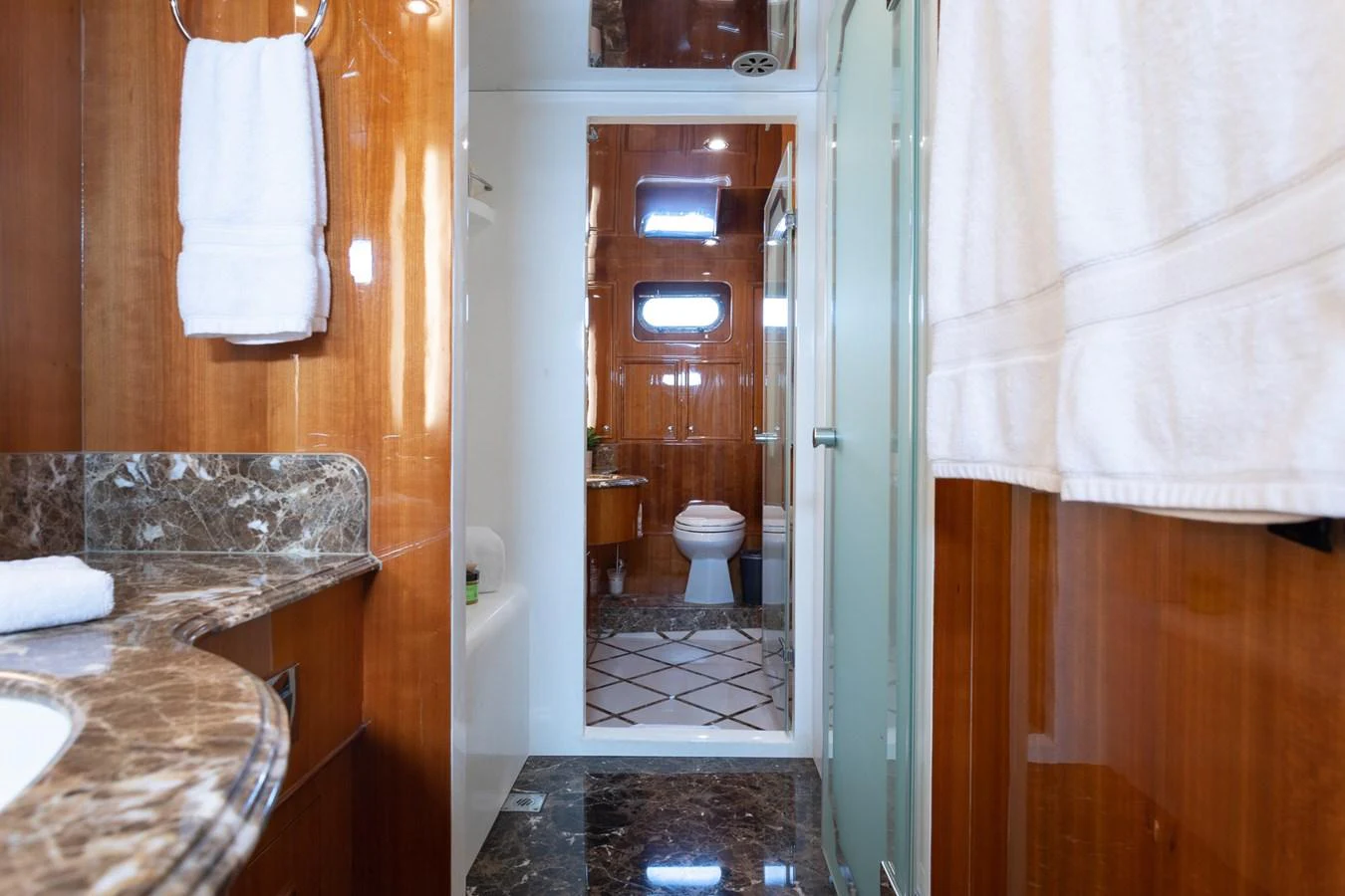 The yacht's bathroom features luxurious marble countertops and wooden paneling, creating an elegant and refined atmosphere. aboard PRIME TIME Yacht for Sale