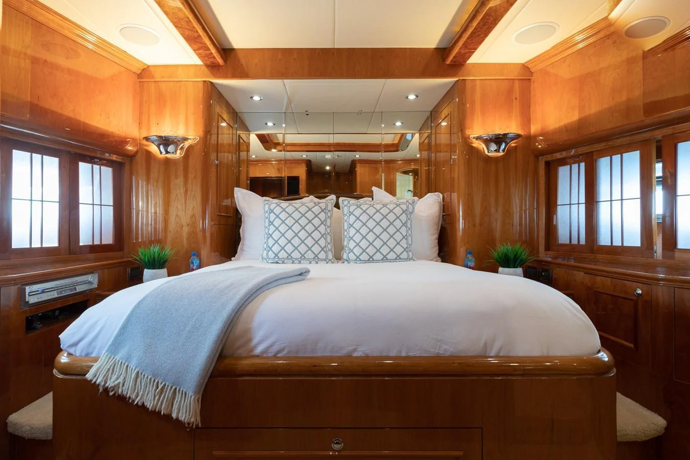 The master stateroom features a luxurious bed with plush pillows and elegant wooden finishes. aboard PRIME TIME Yacht for Sale