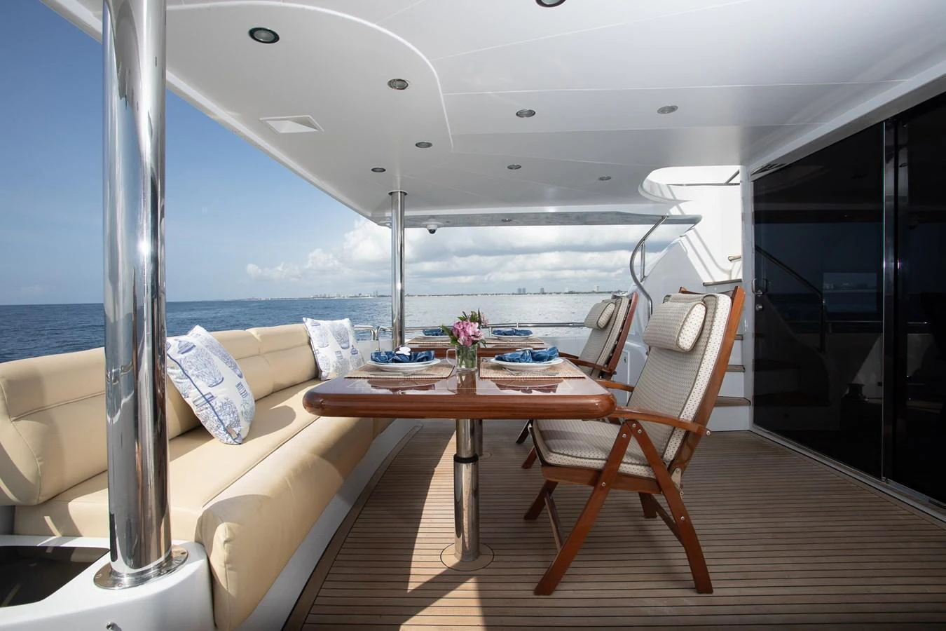 The aft deck features a comfortable dining area with a scenic ocean view. aboard PRIME TIME Yacht for Sale