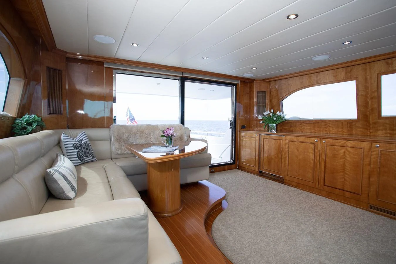 The salon features plush seating, a wooden table, and large windows offering panoramic views. aboard PRIME TIME Yacht for Sale