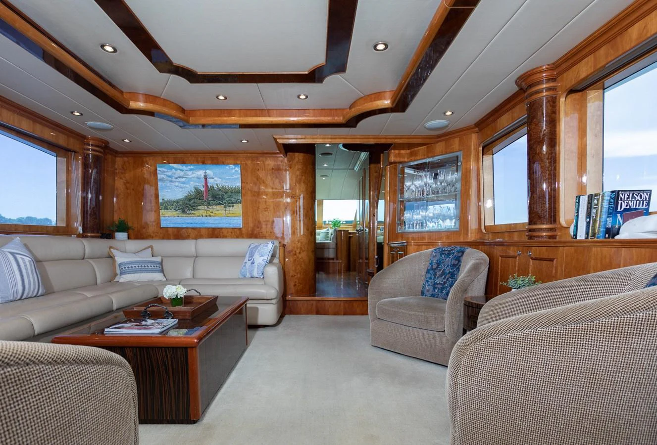 The salon features plush seating, elegant wood finishes, and large windows for a luxurious and comfortable atmosphere. aboard PRIME TIME Yacht for Sale