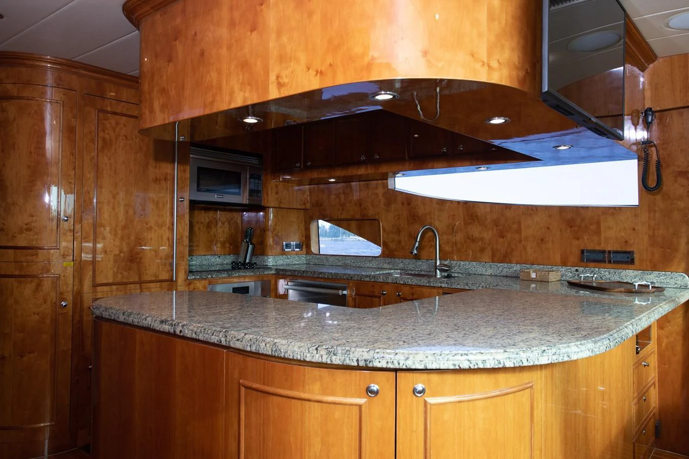 The yacht's galley features elegant wood cabinetry and a spacious granite countertop. aboard PRIME TIME Yacht for Sale