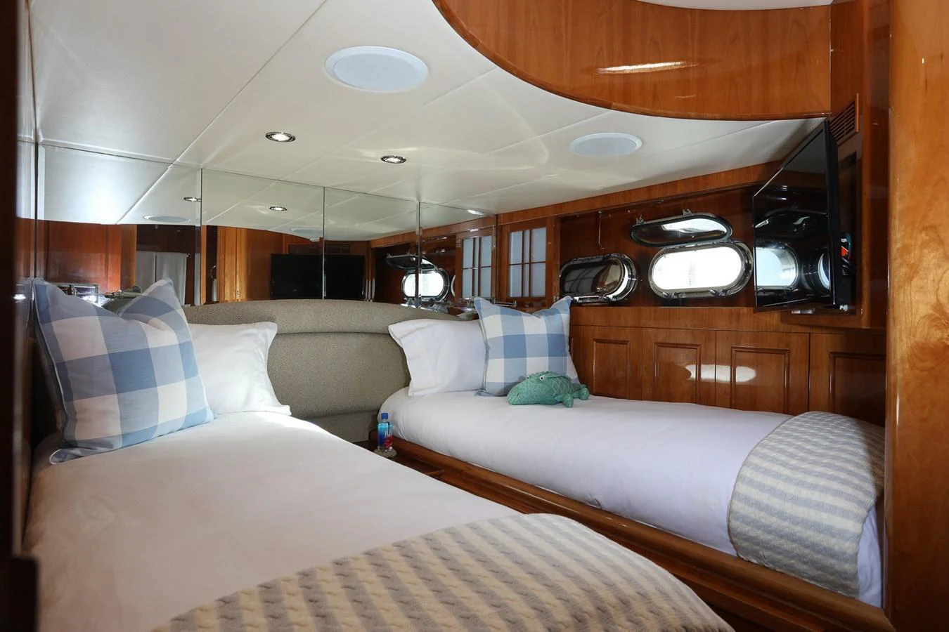The twin stateroom offers a cozy and inviting space with two single beds and elegant wood finishes. aboard PRIME TIME Yacht for Sale
