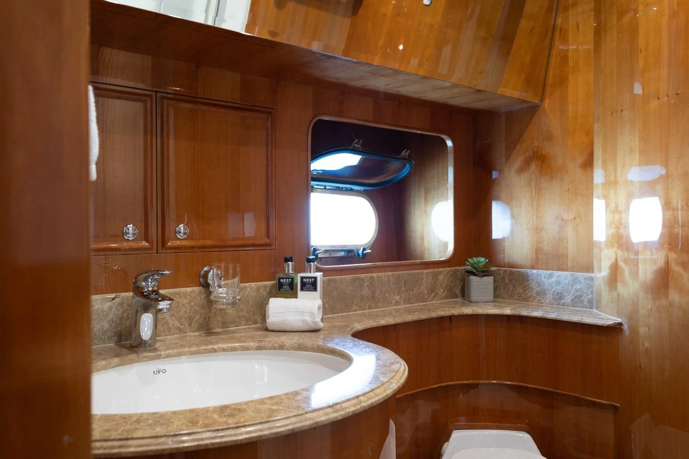 The yacht's bathroom features elegant wooden finishes and a marble countertop. aboard PRIME TIME Yacht for Sale