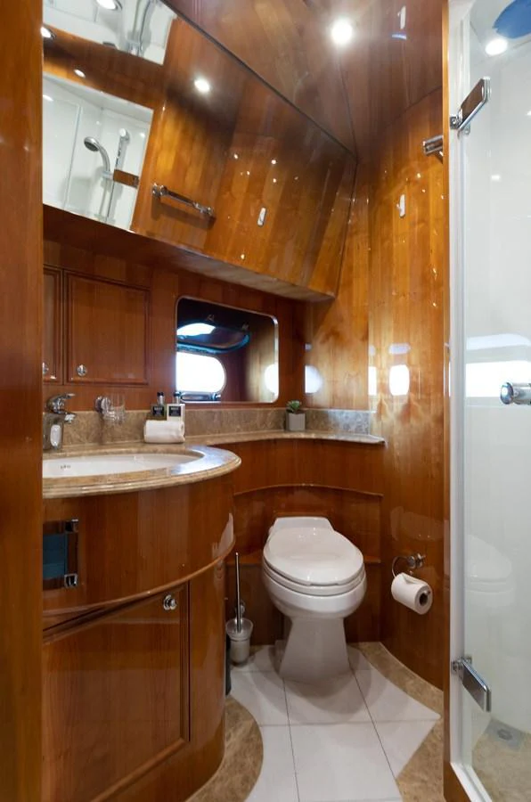 The yacht's bathroom features elegant wooden cabinetry and a modern shower. aboard PRIME TIME Yacht for Sale