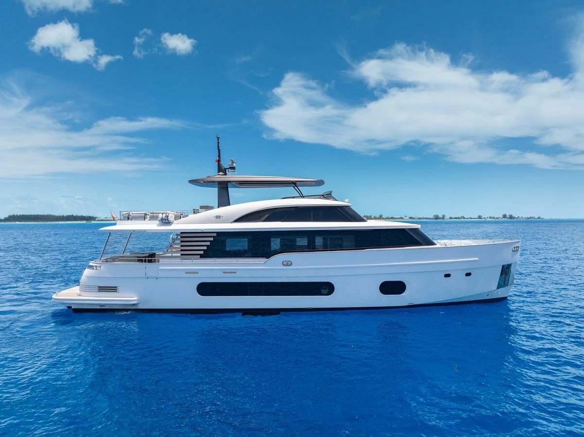 A sleek and modern yacht glides gracefully on the open blue sea under a clear sky. aboard LIFE Yacht for Sale