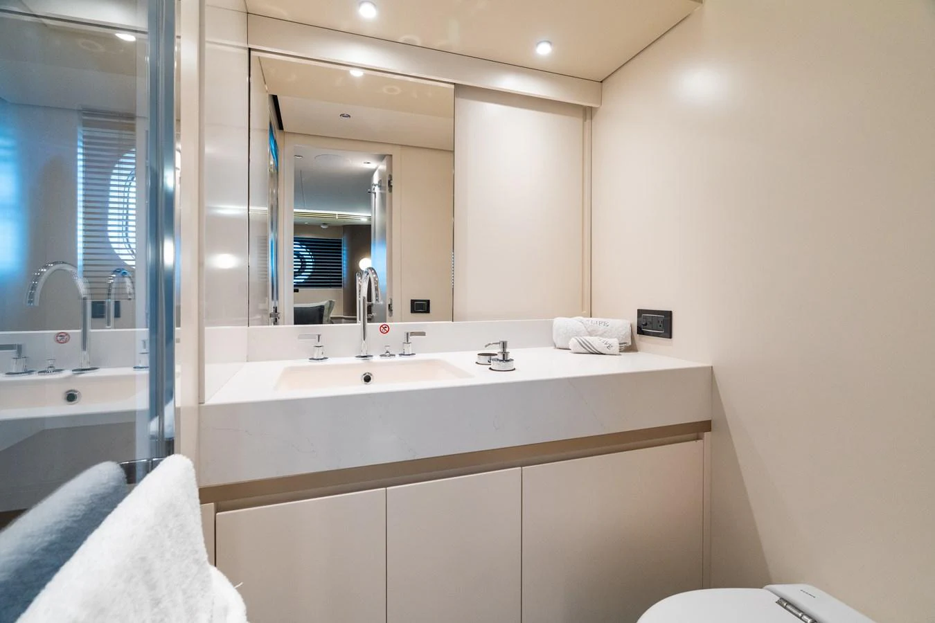The yacht's bathroom features a sleek, modern design with a spacious sink area and elegant fixtures. aboard LIFE Yacht for Sale