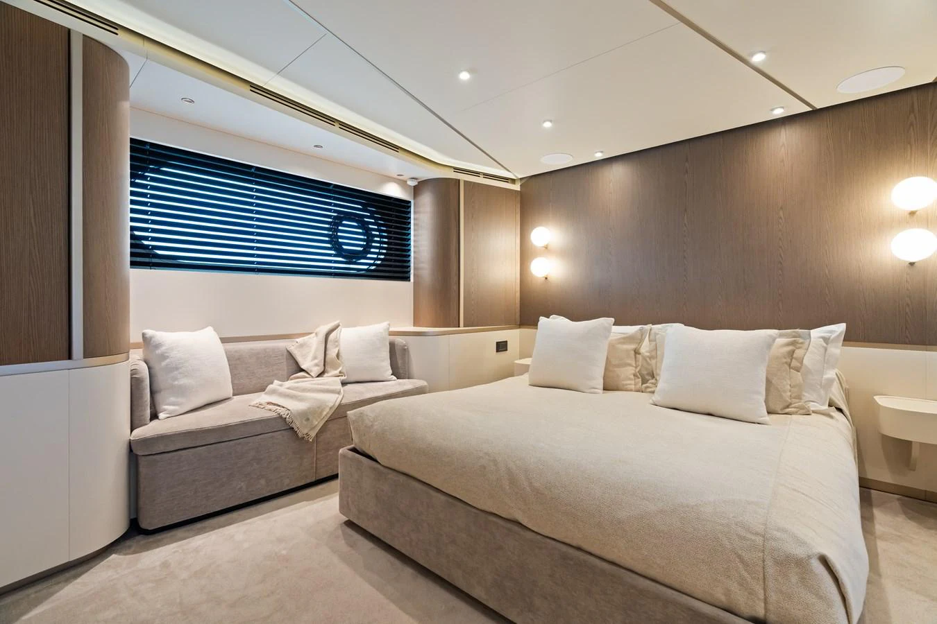 The stateroom features a luxurious bed and a cozy seating area with elegant lighting. aboard LIFE Yacht for Sale