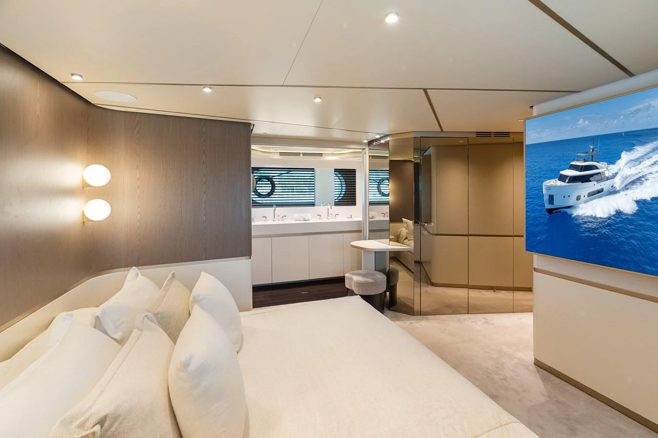 The stateroom features a luxurious bed, modern lighting, and a large screen displaying a serene ocean view. aboard LIFE Yacht for Sale