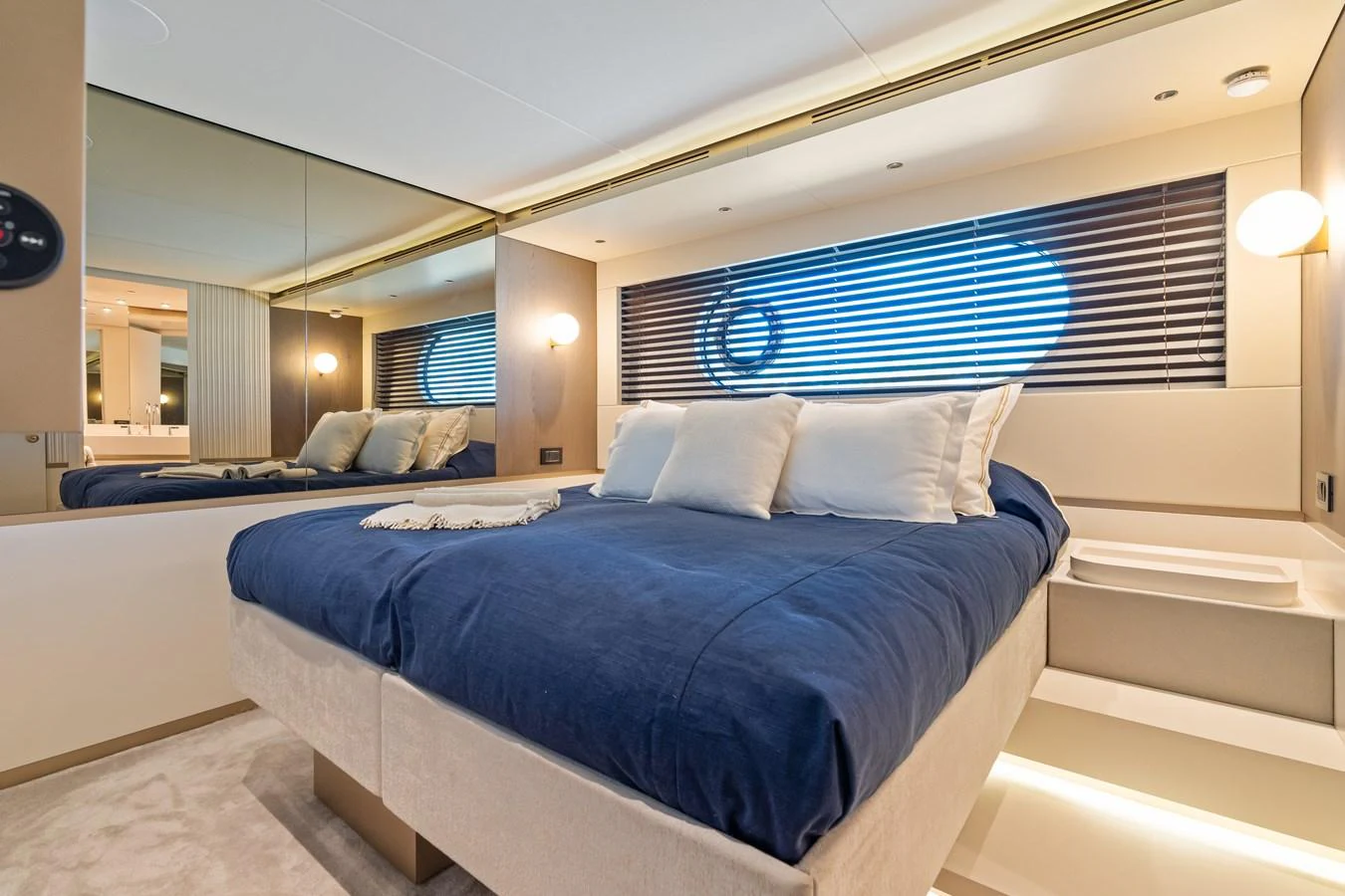 A luxurious stateroom featuring a plush bed with blue bedding and ambient lighting. aboard LIFE Yacht for Sale