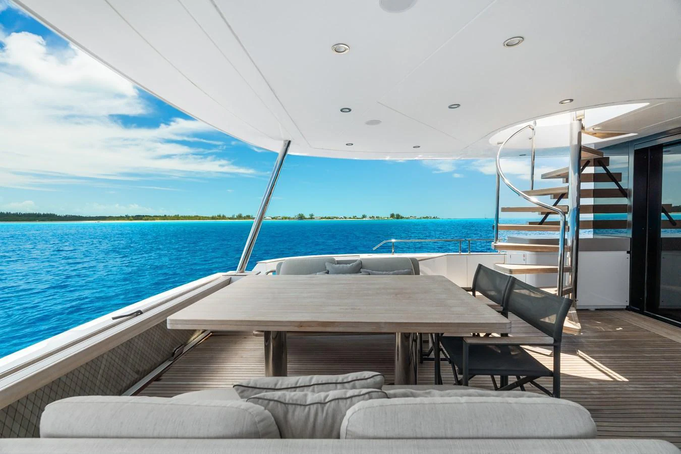 The aft deck offers a serene dining area with stunning ocean views and comfortable seating. aboard LIFE Yacht for Sale