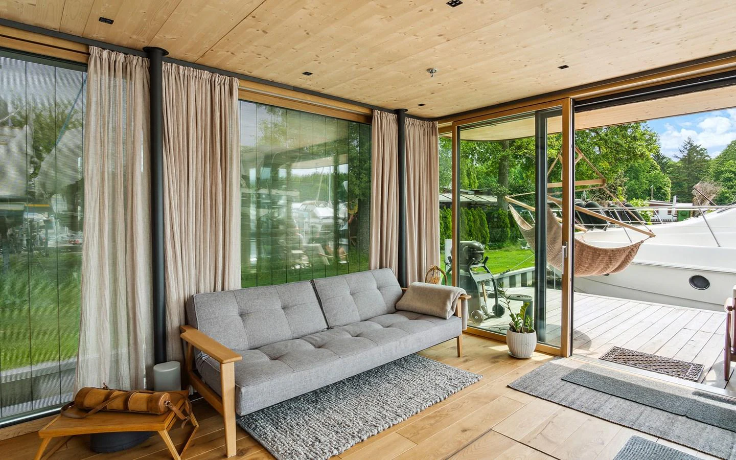 A cozy and modern interior space with large windows offering a view of the outside deck. aboard OHANA Yacht for Sale