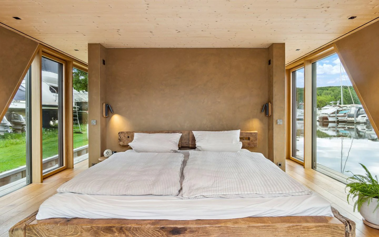 A cozy stateroom with large windows offering a serene view of the marina. aboard OHANA Yacht for Sale
