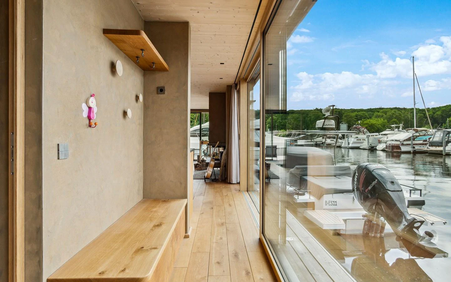 A cozy interior space with wooden accents and large windows overlooking the marina. aboard OHANA Yacht for Sale