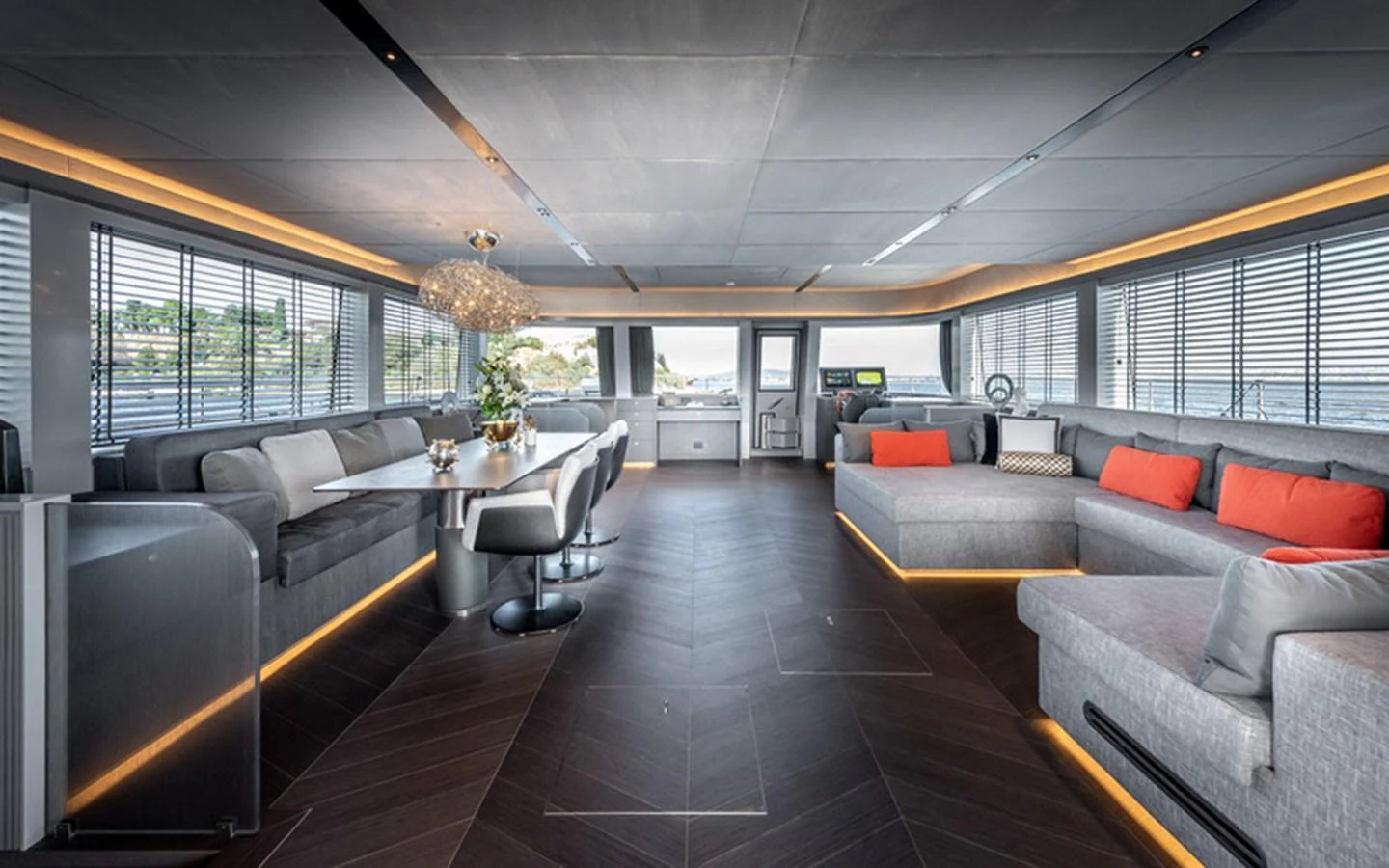 The yacht's salon features modern furnishings with ample seating and a dining area, accentuated by large windows and ambient lighting. aboard SITARA Yacht for Sale
