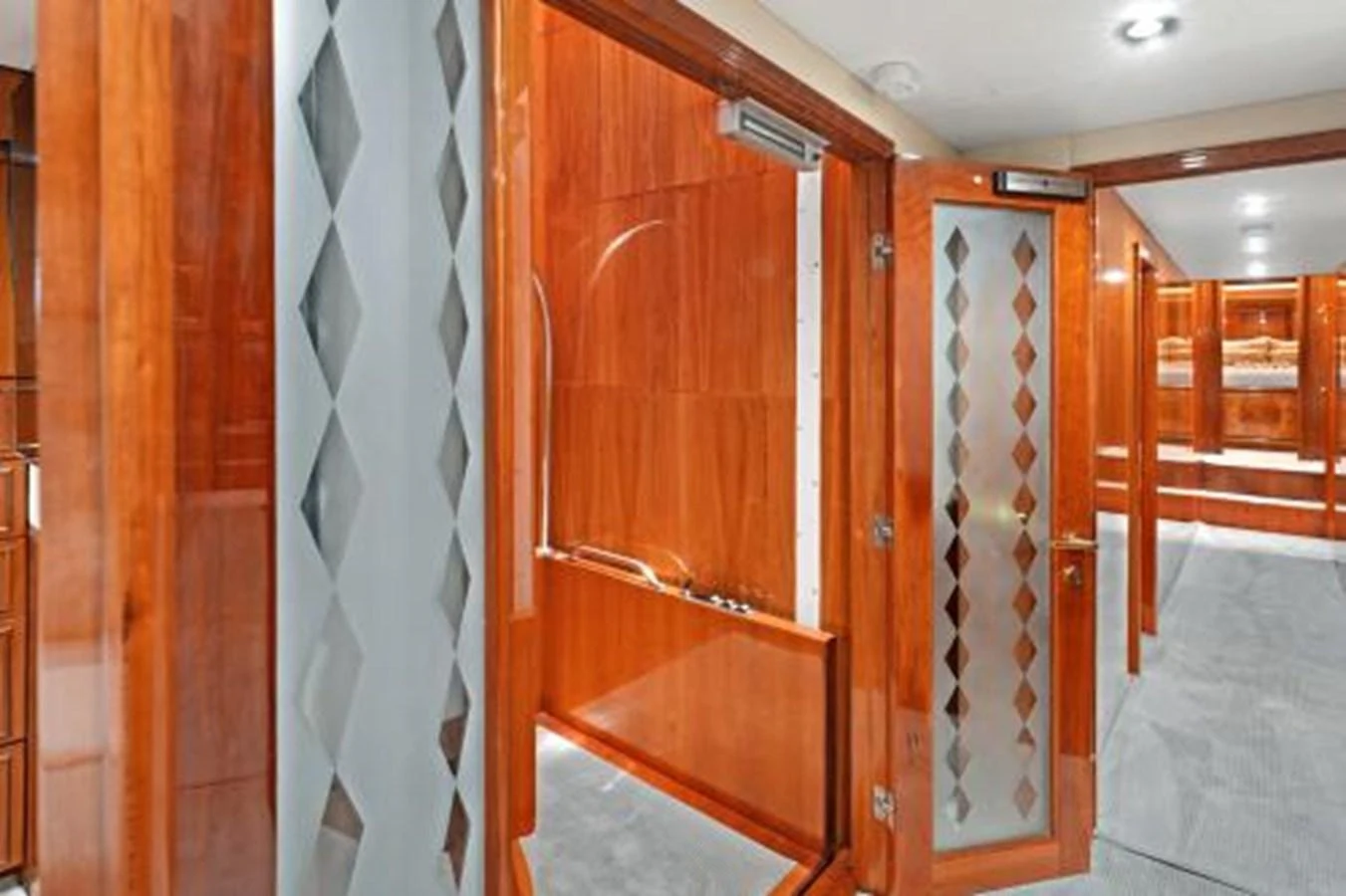 The yacht's interior features polished wood finishes and frosted glass doors, creating a warm and inviting atmosphere. aboard SUE CAROLYN Yacht for Sale